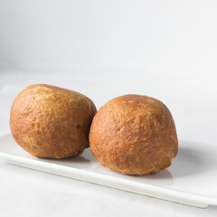 homemade nigerian egg roll in a white ceramic plate, freshly made african egg roll on a white plate, egg wrapped in fried dough