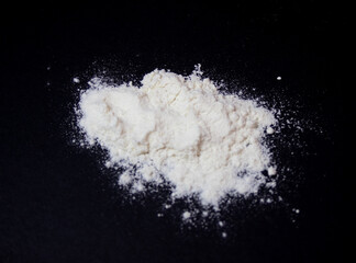 Zenithal photo.White flour pile on a black background. 