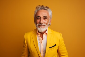 Obraz premium Portrait of a satisfied man in his 60s dressed in a stylish blazer while standing against pastel yellow background