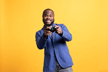 Cheerful player happy after winning gaming console game, isolated over studio background. Joyful...