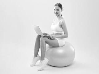 Naklejka premium Slender dark-skinned female blogger in a white tracksuit against a white background. Healthy lifestyle, sports and diet.