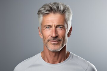 Obraz premium Portrait of a tender man in his 50s sporting a breathable mesh jersey on pastel gray background