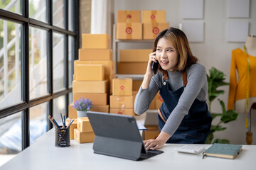 A woman is talking on her cell phone while standing in front of a desk with a la