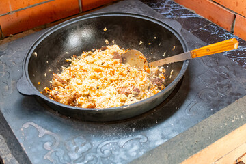 national Central Asian dish pilaf is cooked over an open fire with vegetables and fruits.