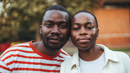A male and female student stand side by side, dressed in casual attire, with expressions of...