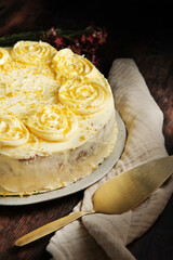 Lemon cake decorated with cream on top, on a rustic wooden table. Sponde cake  