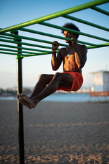 Muscular Brazilian Athlete Performing Calisthenics at Beachside Outdoor Gym.