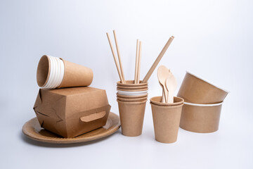 Kraft paper tableware: cups, food boxes, isolated on a light background. A set of various disposable tableware. Recycling and zero waste concept. Mock up