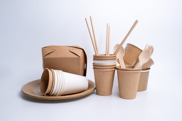 Kraft paper tableware: cups, food boxes, isolated on a light background. A set of various disposable tableware. Recycling and zero waste concept. Mock up