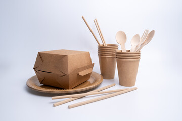 Kraft paper tableware: cups, food boxes, isolated on a light background. A set of various disposable tableware. Recycling and zero waste concept. Mock up