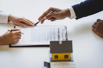 Real estate agents negotiate for businessmen to legally sign home purchase agreements contract ,...
