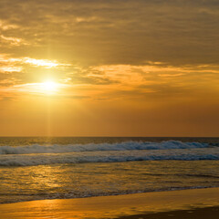Sunrise on the beach and ocean waves on a tropical sea