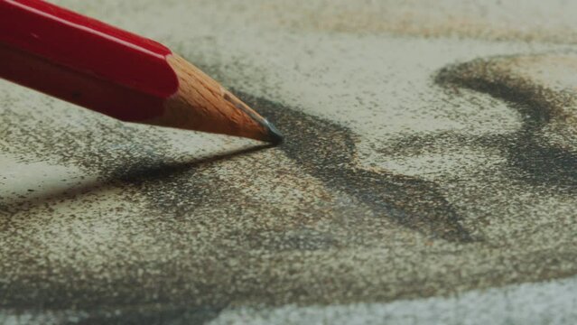 Unseen artist drawing lips with graphite pencil on paper while creating portrait. Close-up shot