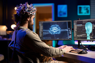 Developer with EEG headset on programming brain transfer into computer virtual world, becoming one...