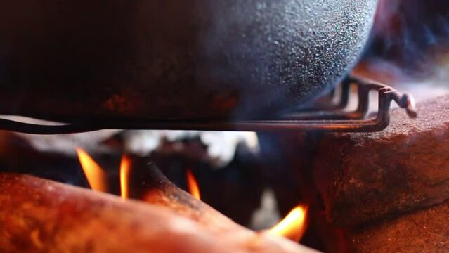 cooking in a cauldron over an open fire
