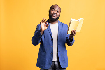 Portrait of jolly african american man recommending interesting book after being entertained by...