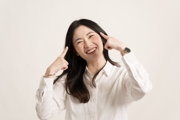 Portrait young Asia lady feel happiness with positive expression wear white shirt isolate on white background.Beautiful young Asian woman pointing finger to her face.