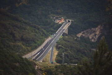 Italy, Genoa. Part of a freeway with a tunnel and a bridge. Genova est. cars move along the...