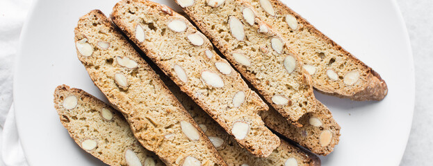 Overhead view of almond biscotti on a white plate, almond cantucci cookies on a white plate,...
