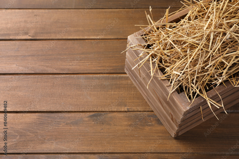 Sticker Dried straw in crate on wooden table, space for text