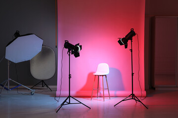 Photo background in neon lights and professional lighting equipment inside modern studio