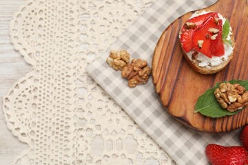 Delicious ricotta bruschetta with strawberry and walnut served on table, flat lay. Space for text
