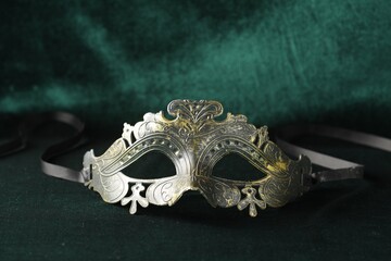 Theater arts. Venetian carnival mask on green fabric