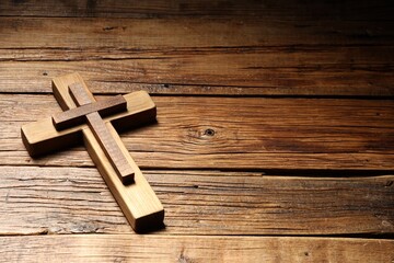 Cross on wooden table, space for text. Religion of Christianity