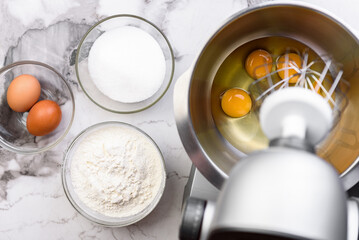 Beating eggs with an electric mixer for sponge biscuit cake dough.