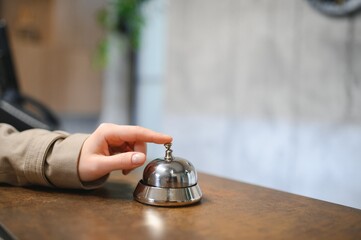 Hand of a woman using a hotel bell