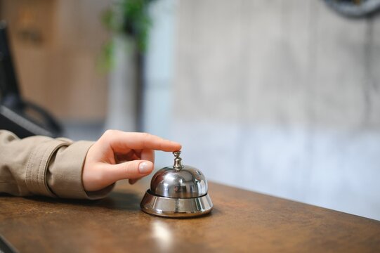 Hand of a woman using a hotel bell