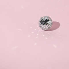 Shiny disco ball on pink background- Space for text.