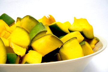 Close-up View Of Slices of Mango for Mango Pickle In White Bowl, Isolated On Black Background