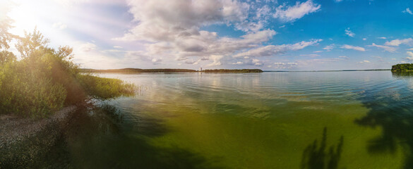 Panorama view from above of the summer landscape. Orange sunset sky, fields and forests, rivers and roads