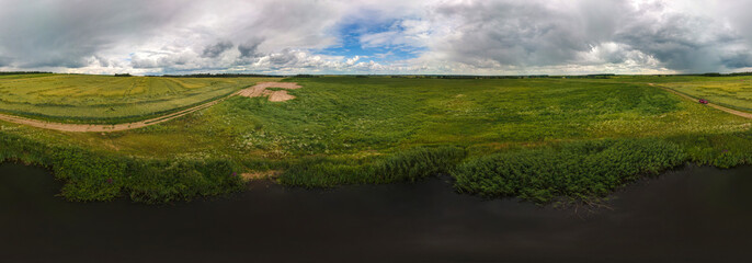 A view from a height on a beautiful rural summer landscape. Green fields and blue sky.