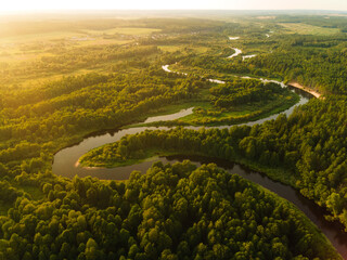 View from a height of a flying drone on a summer landscape. Lake and river, field and forest.