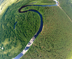 View from a height of a flying drone on a summer landscape. Lake and river, field and forest.