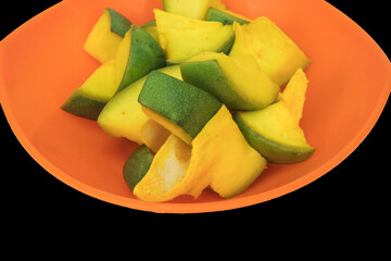 Slices of Mango for Mango Pickle in Saffron Color Bowl, Isolated In Black Background