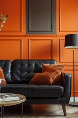 A cozy living room with orange walls and a black leather couch, perfect for relaxing
