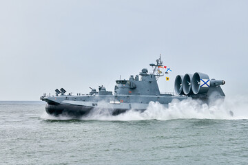 Hovercraft warship armed with armament sails into sea toward military target to attack and destroy...