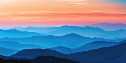 Obraz premium A breathtaking view of a mountain range at sunset with warm colors and misty valleys