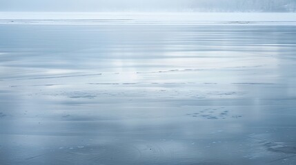 Obraz premium The smooth and mirrorlike surface of a frozen lake enhanced by the faint hint of shimmering colors