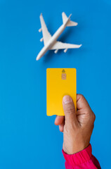 Summer vacation ticket purchase concept with commercial airplane in the background with blue and credit card in one hand
