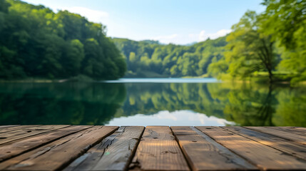 A tranquil lake view seen from a wooden deck, surrounded by lush green forests reflected in the still water.