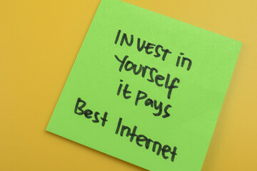 Concept of Invest in Yourself it Pays Best Internet write on sticky notes isolated on Wooden Table.