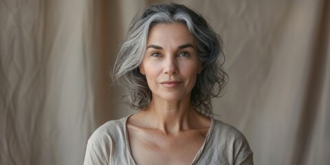 Fototapeta premium A portrait of an elderly woman with grey hair wearing a tan shirt, ideal for use in senior-focused or age-related projects