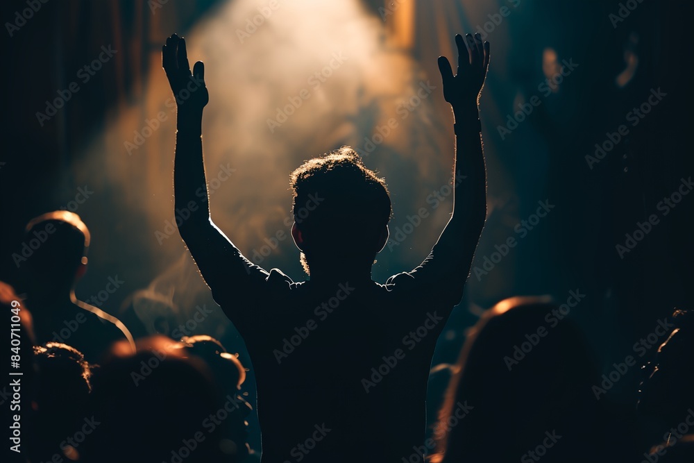 Poster man standing in front of a crowd with his hands up in the air