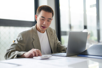 Attractive confident millennial Asian Business man using laptop computer and professional working investor start up project business planning in office.