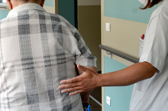 gros plan sur la main d'une infirmi&egrave;re accompagnant un vieil homme