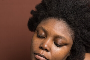 Woman with Black afro curly hair with shrinkage, african woman with Type 4c hair with a brown...